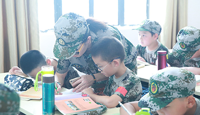 上海西点军训夏令营辅导员正在给孩子们辅导作业